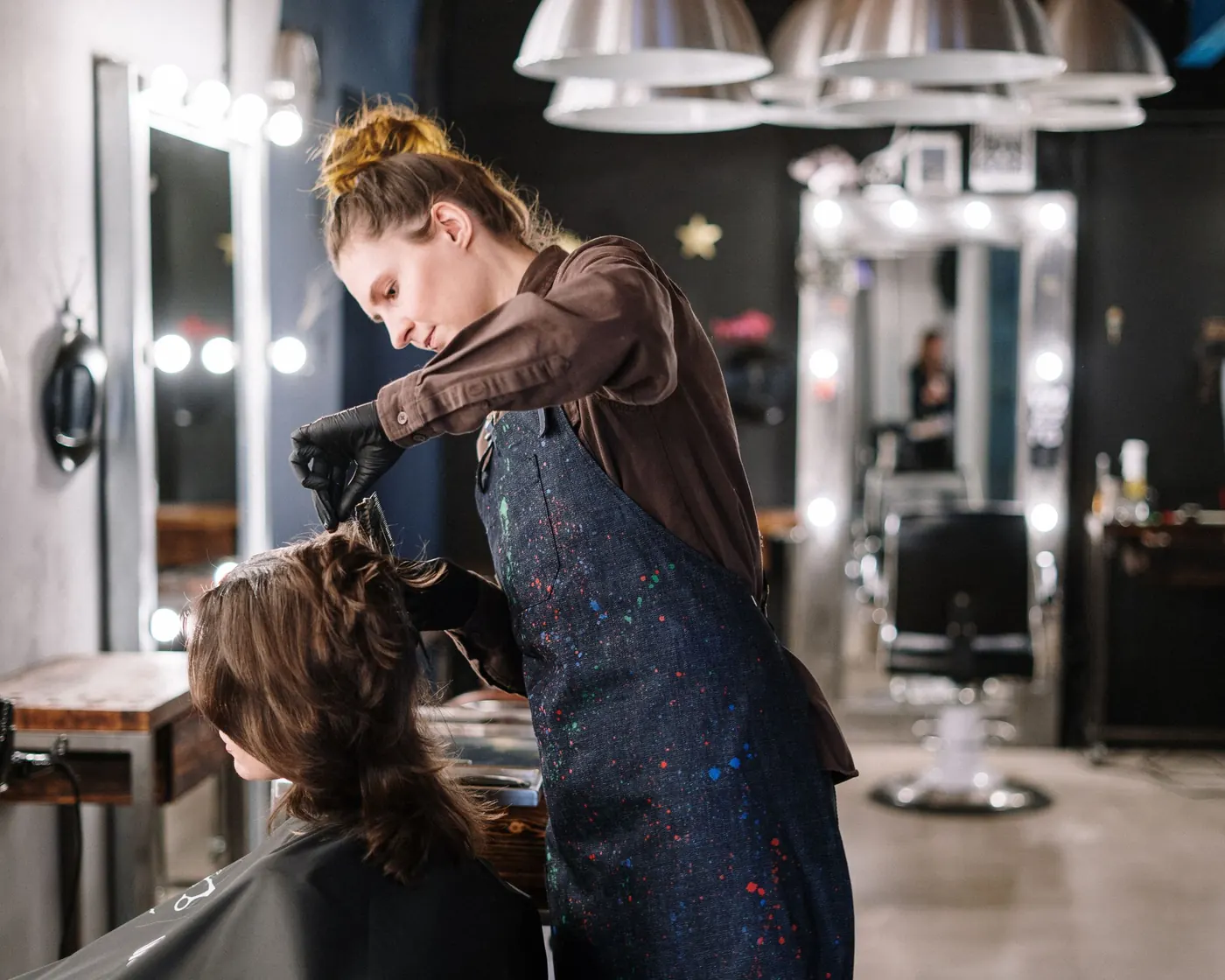 A stylist colouring a client's hair in a modern salon