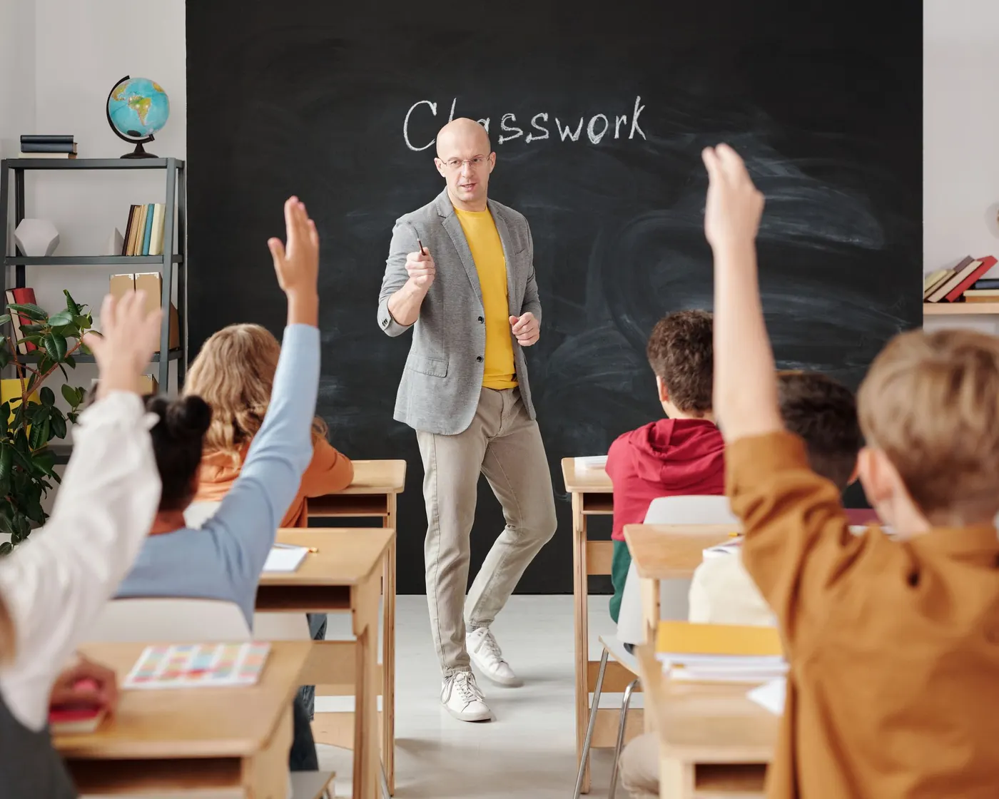 Students raising their hands in a classroom